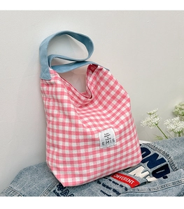Gros plan du sac cabas à carreaux roses et blancs avec étiquette EMIS et sangle bleue
