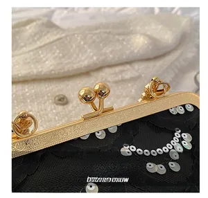 Detailed macro view of vintage gold engraved frame and black lace on evening clutch bag