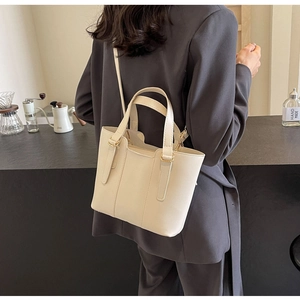 Vista dettagliata della borsa tote in pelle bianco crema con manici e tracolla regolabile