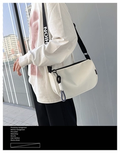 Détail du sac bandoulière blanc en nylon avec sangle à lettres contrastées et zip noir chic