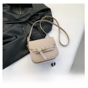 Nahaufnahme der beige Satteltasche mit Gürtelschnalle und Größenvergleich zum Smartphone