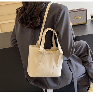 Elegante borsa a secchiello crema con tracolla regolabile e manico superiore fisso
