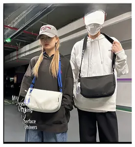 Détail de sac bandoulière demi-lune avec sangle ajustable et fermeture éclair à nœud
