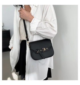 Detail einer schwarzen Vintage-Satteltasche mit goldener Schnalle und Lederriemendekor
