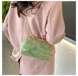 Detail of light green sequined embroidery clasp bag with a gold metal chain strap