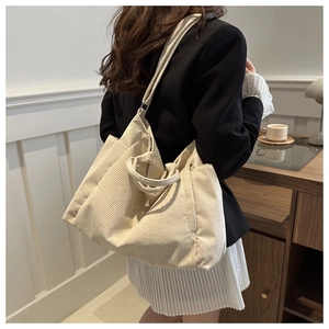 Détail du sac fourre-tout en velours côtelé crème avec bandoulière et poignée robuste