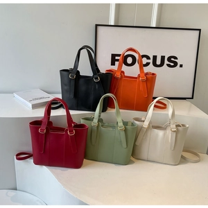 Dettaglio di borse tote in cinque colori tra cui arancione, verde e bordeaux