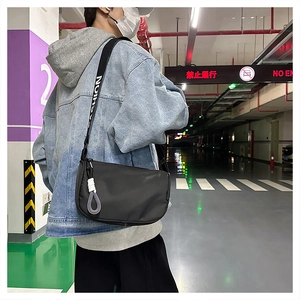 Détail du sac en nylon noir avec large bandoulière FASHION et pendentif tressé