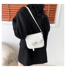 Detailansicht der weißen Leder-Satteltasche mit Schnalle an der Schulter des Models