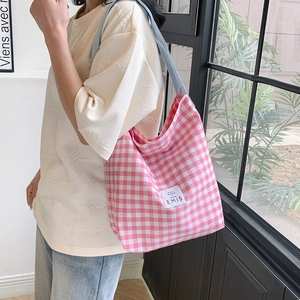 Détail d'un sac cabas à carreaux rose et blanc avec logo EMIS et bandoulière bleue