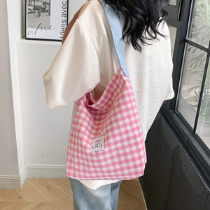 Vue détaillée d'un sac cabas en toile à carreaux roses avec bandoulière bleu clair