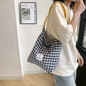Gros plan du sac cabas en toile à damier avec bandoulières jaunes et étiquette de marque EMIS