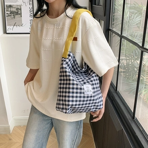 Détail du sac cabas en toile à carreaux avec bandoulière jaune et logo EMIS distinctif