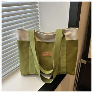 Détail du sac fourre-tout en toile olive et beige avec un patch de mode en cuir brun