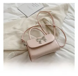 Detailed macro view of a pink mini crossbody bag featuring a silver bow metal decoration