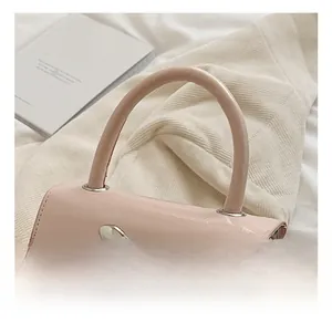 Detail view of the pink mini handbag showing the smooth top handle and silver bow hardware