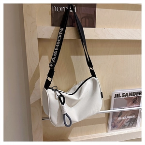 Détail du sac blanc en demi-lune avec bandoulière noire lettrée 'FASHION' et zip