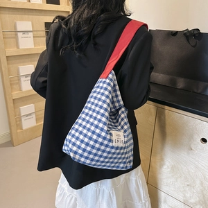 Détail du sac cabas à carreaux bleus et blancs avec poignée rouge et étiquette EMIS