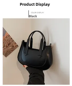 Detail view of the black crescent shoulder bag with dual flat handles and matte PU finish