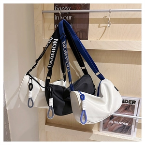 Détail de sacs croissant en nylon avec bandoulières jacquard et cordons tissés déco
