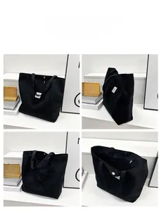 Detail of black canvas tote bag showing metal snap closure and interior zipper pocket