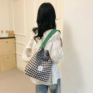 Vue détaillée du dos d'un sac cabas à carreaux noir et blanc avec une sangle verte