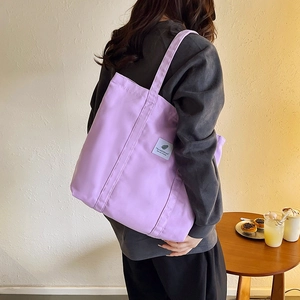 Close-up of a lavender canvas tote bag showing the durable texture and white woven label