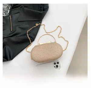 Detail view of champagne glitter evening clutch bag with metal bow clasp and gold chain