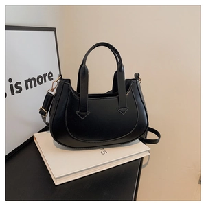 Detail of minimalist black crescent bag with golden buckle and sleek leather texture