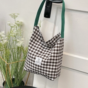 Détail du sac cabas à carreaux avec logo EMIS et bandoulière tissée verte