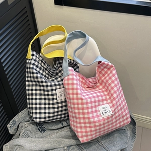 Détail de cabas en toile à carreaux coréens en bleu et rose avec sangles contrastées
