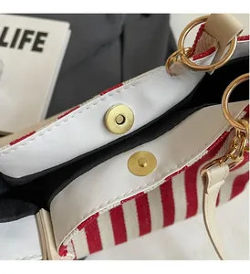 Detail of red and white striped tote with gold magnetic snap closure and metal rings
