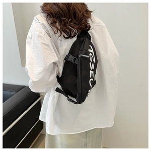 Dettaglio della borsa a tracolla in nylon nero con stampa grafica TGSEU bianca audace