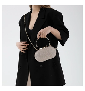 Champagne gold sequin evening clutch bag with metal handle worn by model in black suit