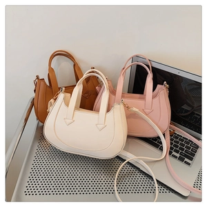 Detailed view of crescent shoulder bags in cream, pink, and caramel with adjustable straps