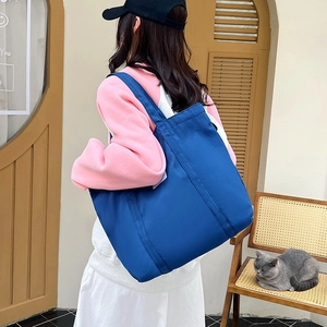 Large capacity navy blue canvas tote bag for women shown in a cozy home setting