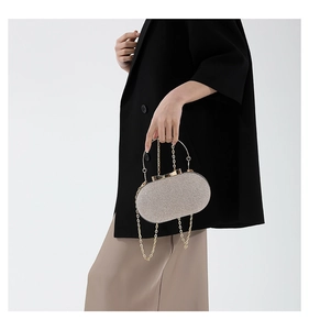 Detailed close-up of champagne gold sequined evening clutch with metal handle and chain