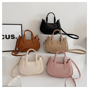 Five crescent shoulder bags in diverse colors displayed on modern white steps