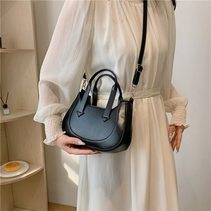 Elegant black minimalist crescent shoulder bag with golden hardware and adjustable strap