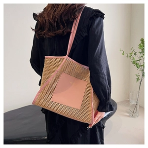 Detail der großen gewebten Stroh-Tasche mit rosa Ledertasche und langen Schultergurten