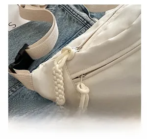 Detail showing smooth zipper with woven cord puller and durable buckle on white chest bag