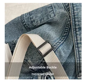 Detail view of washed denim bag with adjustable plastic buckle and durable woven strap