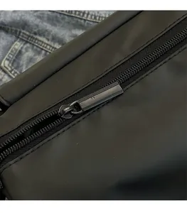 Detailed macro view of black nylon shoulder bag with shiny metal zipper and smooth hardware