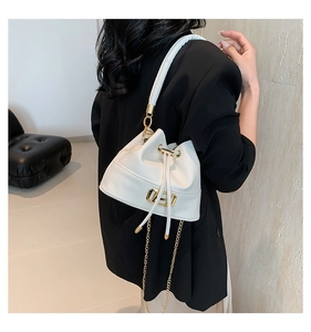 Close-up of white leather bucket bag featuring gold metal chain and drawstring detail