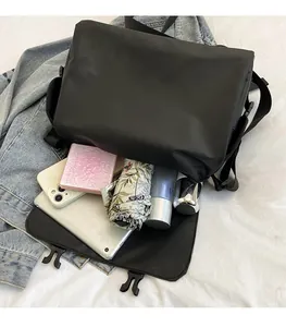 Top view of spacious black messenger bag interior with tablet, phone and daily essentials