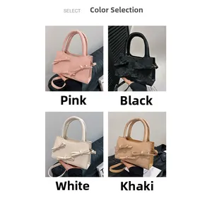 Detail view of bow-knot handbag in pink, black, white, and khaki with shoulder straps