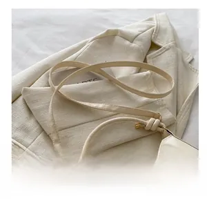 Detail of adjustable cream leather shoulder strap with gold buckle and knot detail