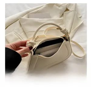 Detail view of cream white leather bag interior showing capacity for phone and wallet