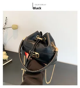 Detail of black bucket bag with soft leather texture and golden drawstring hardware