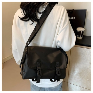 Close-up of black nylon messenger bag with buckle closure and adjustable strap